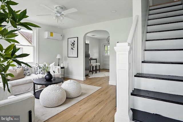 12 N Hawthorne Rd N, Middle River, MD 21220 - living area with arched walkways, an AC wall unit, ceiling fan, light wood-type flooring, and stairs