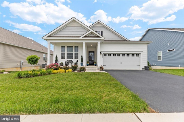 8051 Keystone Dr, Breinigsville, PA 18031 - view of front of house with driveway, a garage, a front yard, and covered porch
