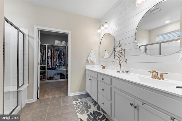 8051 Keystone Dr, Breinigsville, PA 18031 - bathroom with double vanity, a walk in closet, a shower stall, tile patterned floors, and baseboards