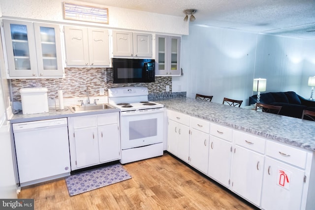17 139th St Unit 105, Ocean City, MD 21842 - kitchen with white appliances, a sink, tasteful backsplash, light wood finished floors, and white cabinets