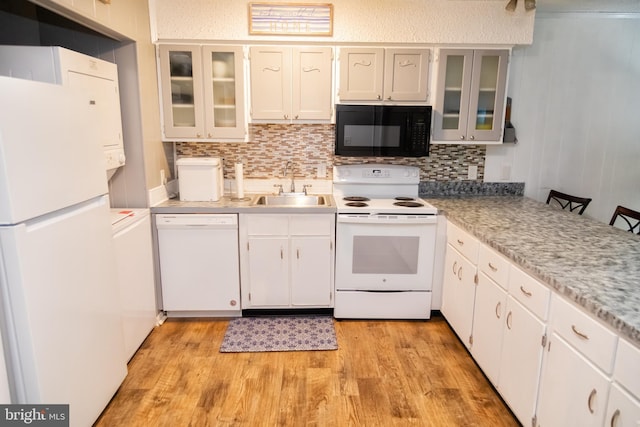 17 139th St Unit 105, Ocean City, MD 21842 - kitchen featuring white appliances, a sink, light wood-style flooring, tasteful backsplash, and washer / clothes dryer