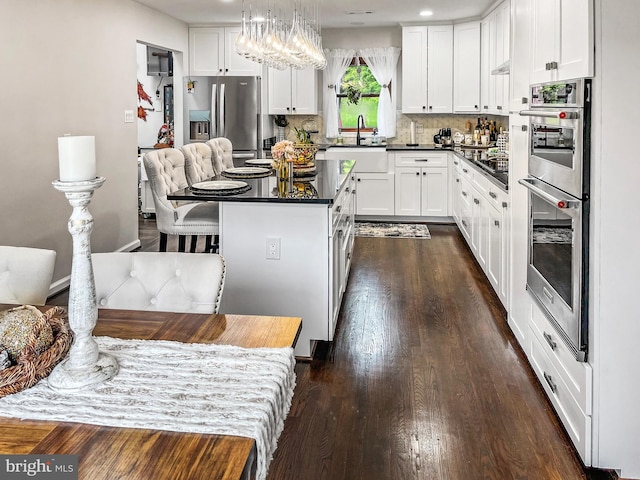 11500 Golden Post Ln, Gaithersburg, MD 20878 - kitchen featuring a sink, appliances with stainless steel finishes, a chandelier, dark countertops, and a center island