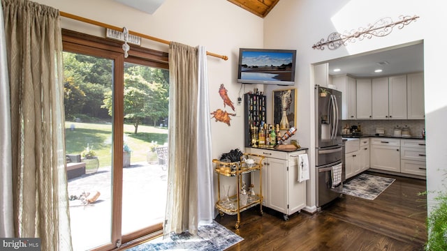 11500 Golden Post Ln, Gaithersburg, MD 20878 - kitchen with stainless steel fridge, dark wood-type flooring, lofted ceiling, dark countertops, and decorative backsplash