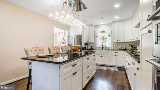 11500 Golden Post Ln, Gaithersburg, MD 20878 - kitchen with dark countertops, appliances with stainless steel finishes, a breakfast bar area, a sink, and backsplash