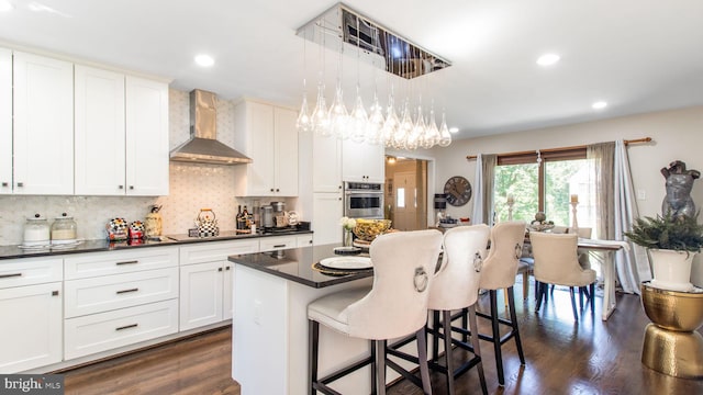 11500 Golden Post Ln, Gaithersburg, MD 20878 - kitchen featuring wall chimney exhaust hood, oven, dark countertops, a kitchen bar, and dark wood-style flooring