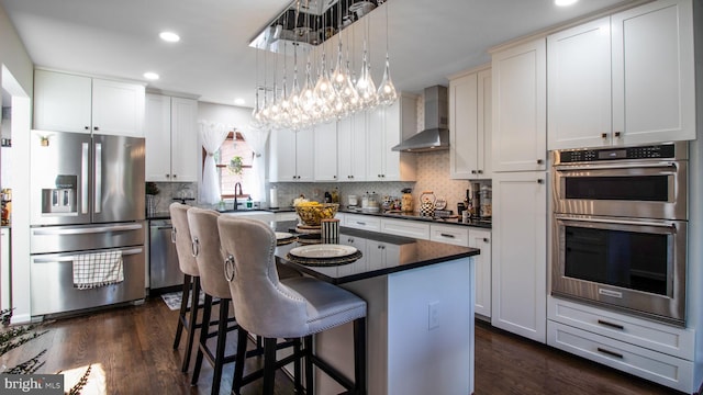 11500 Golden Post Ln, Gaithersburg, MD 20878 - kitchen with stainless steel appliances, wall chimney range hood, dark countertops, dark wood-style flooring, and a kitchen island