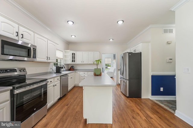 20 Doe Hill Ct, Camden Wyoming, DE 19934 - kitchen featuring appliances with stainless steel finishes, white cabinetry, ornamental molding, a center island, and wood finished floors