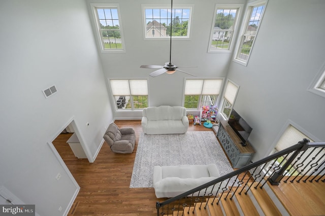 20 Doe Hill Ct, Camden Wyoming, DE 19934 - living area with a towering ceiling, wood finished floors, baseboards, ceiling fan, and healthy amount of natural light
