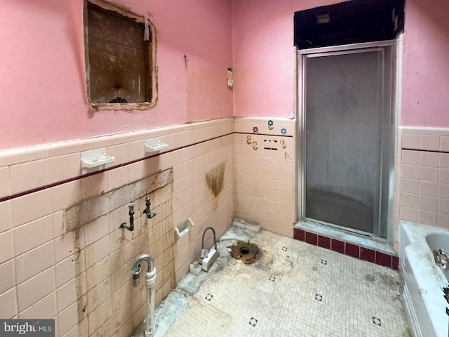 2244 E Washington Ln, Philadelphia, PA 19138 - bathroom featuring tile walls, a wainscoted wall, a stall shower, a tub, and tile patterned floors