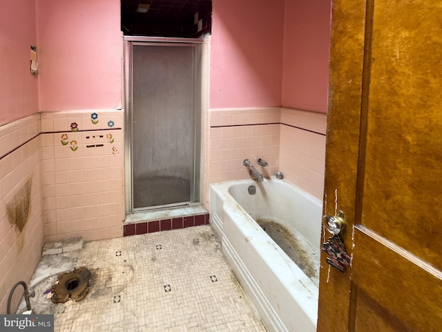 2244 E Washington Ln, Philadelphia, PA 19138 - bathroom with a shower stall, a bath, tile patterned flooring, a wainscoted wall, and tile walls