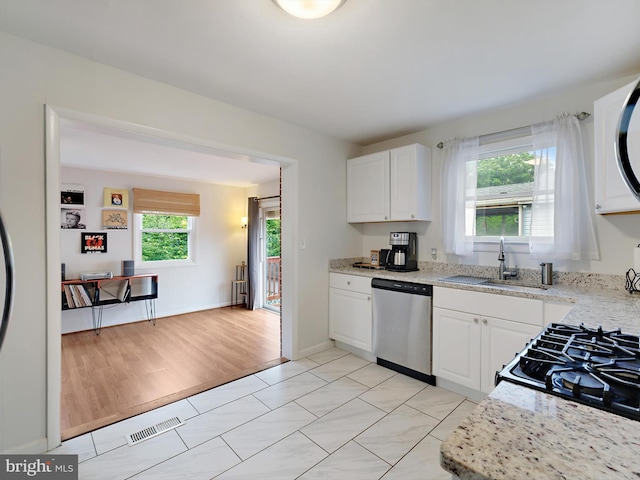 8579 Main Ave, Pasadena, MD 21122 - kitchen featuring stainless steel dishwasher, a sink, white cabinets, and stove