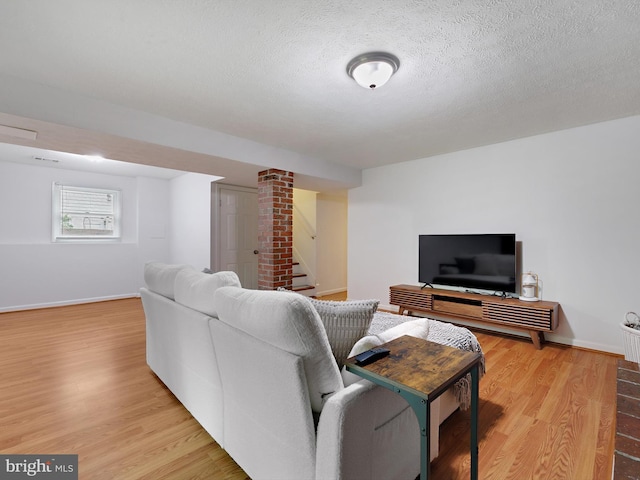 8579 Main Ave, Pasadena, MD 21122 - living area featuring light wood finished floors, baseboards, a textured ceiling, and stairway