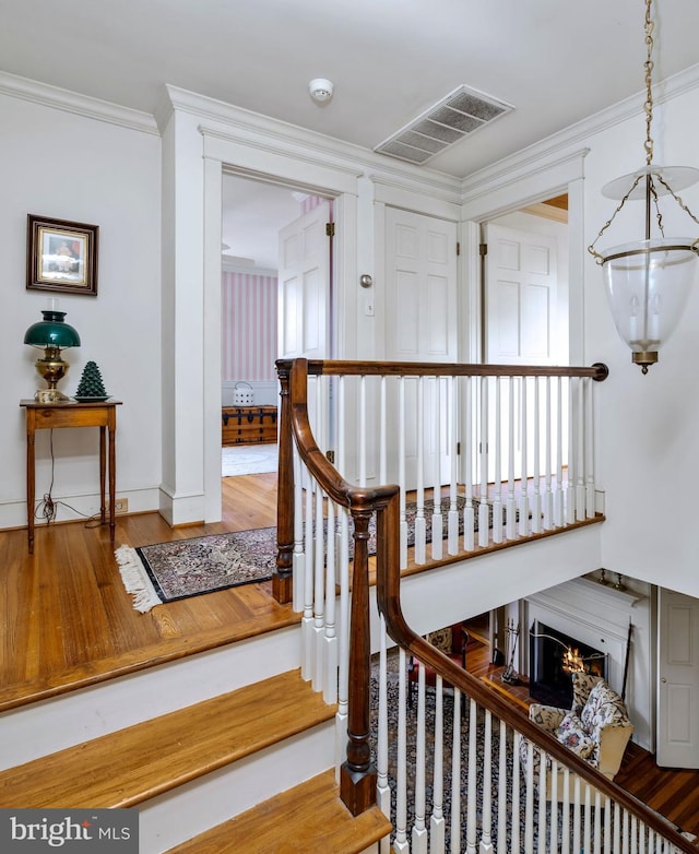 528 E Center Ave, Newtown, PA 18940 - staircase featuring a warm lit fireplace, wood finished floors, and crown molding