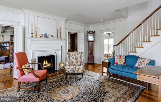 528 E Center Ave, Newtown, PA 18940 - living room featuring wood finished floors, ornamental molding, a warm lit fireplace, and stairway