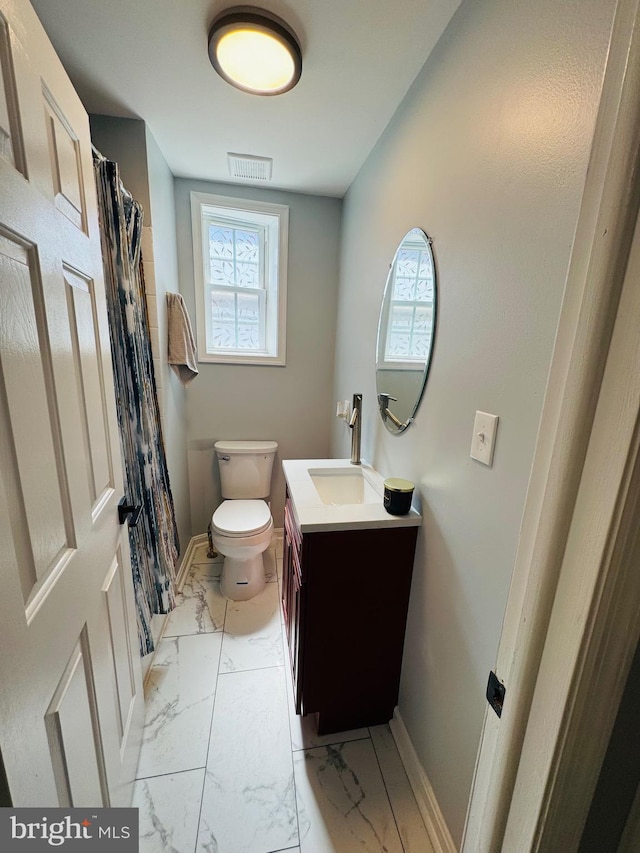 1402 W Saratoga St, Baltimore, MD 21223 - bathroom featuring vanity, marble finish floors, toilet, baseboards, and healthy amount of natural light