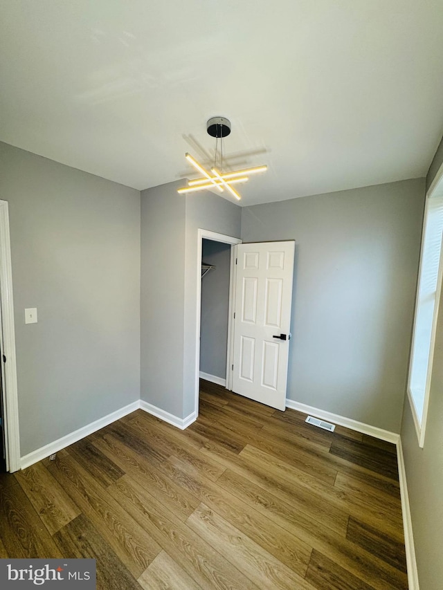 1402 W Saratoga St, Baltimore, MD 21223 - spare room featuring wood finished floors, a chandelier, and baseboards