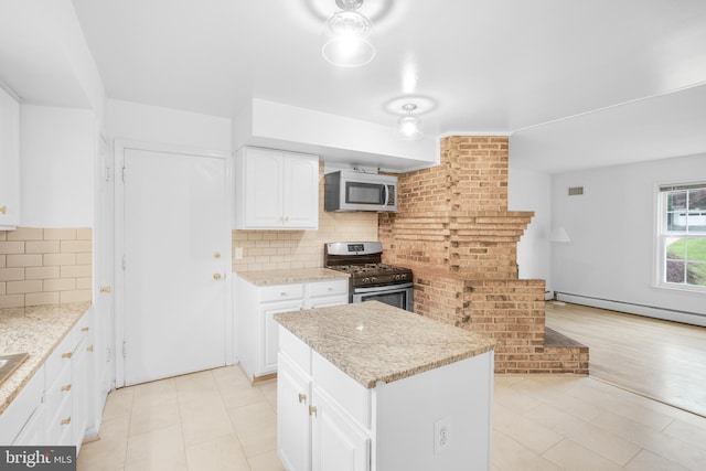 8007 Lewinsville Rd, Mclean, VA 22102 - kitchen featuring appliances with stainless steel finishes, a baseboard radiator, decorative backsplash, and white cabinets
