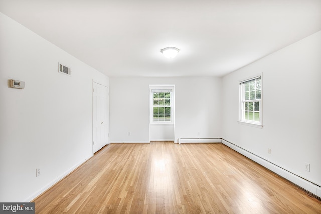 8007 Lewinsville Rd, Mclean, VA 22102 - empty room featuring light wood-style floors, baseboards, baseboard heating, and a baseboard heating unit