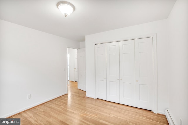 8007 Lewinsville Rd, Mclean, VA 22102 - unfurnished bedroom with a baseboard heating unit, light wood finished floors, baseboards, and a closet