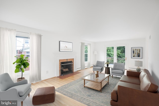 8007 Lewinsville Rd, Mclean, VA 22102 - living room featuring healthy amount of natural light, wood finished floors, a brick fireplace, and a baseboard radiator