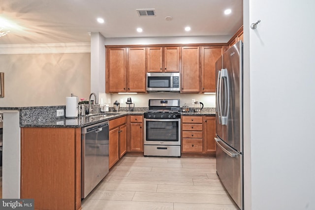 15255 Leicestershire St, Woodbridge, VA 22191 - kitchen with appliances with stainless steel finishes, a sink, brown cabinets, dark stone countertops, and crown molding