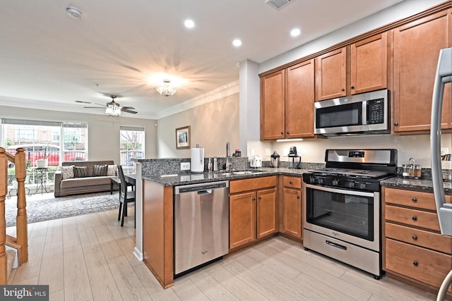 15255 Leicestershire St, Woodbridge, VA 22191 - kitchen with appliances with stainless steel finishes, brown cabinetry, crown molding, a peninsula, and light wood finished floors