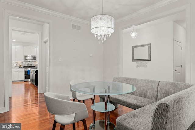 255 Summit Ave, Conshohocken, PA 19428 - dining room with light wood-style flooring, a chandelier, crown molding, and baseboards