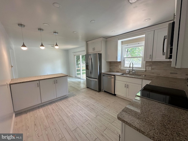 426 Parkwynne Rd, Lancaster, PA 17601 - kitchen with appliances with stainless steel finishes, a sink, light wood-type flooring, backsplash, and decorative light fixtures