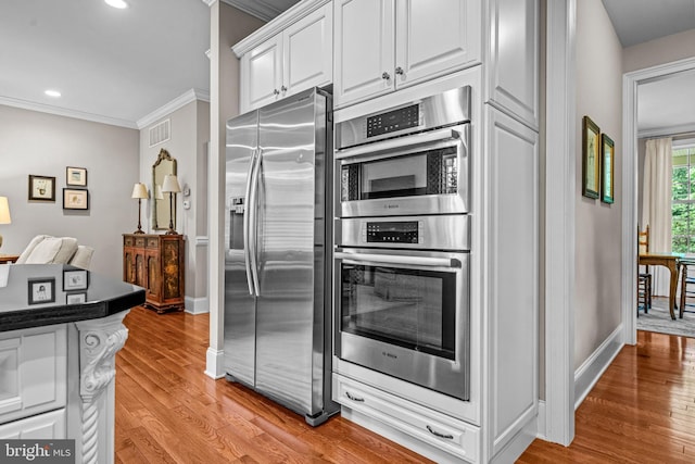 1165 Fulling Mill Ln, Haddon Heights, NJ 08035 - kitchen with appliances with stainless steel finishes, ornamental molding, light wood-type flooring, white cabinets, and recessed lighting
