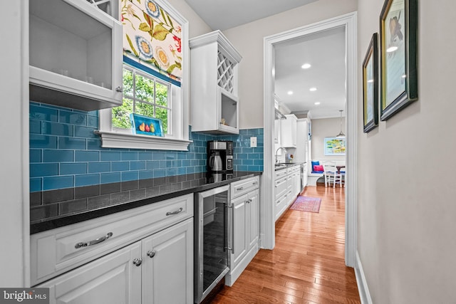 1165 Fulling Mill Ln, Haddon Heights, NJ 08035 - kitchen with beverage cooler, dark countertops, light wood-style flooring, decorative backsplash, and white cabinets
