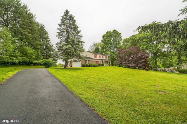 6 Cottage Ln, Glen Mills, PA 19342 - view of front facade featuring a front yard, a garage, driveway, and view of scattered trees