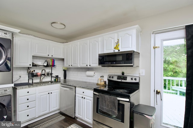 13732 Moccasin Ct, Woodbridge, VA 22193 - kitchen featuring appliances with stainless steel finishes, a sink, stacked washer and clothes dryer, and plenty of natural light