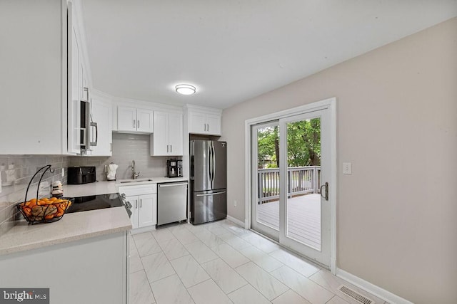 20429 Ambassador Ter Unit 20429, Germantown, MD 20874 - kitchen featuring stainless steel appliances, a sink, tasteful backsplash, and white cabinets
