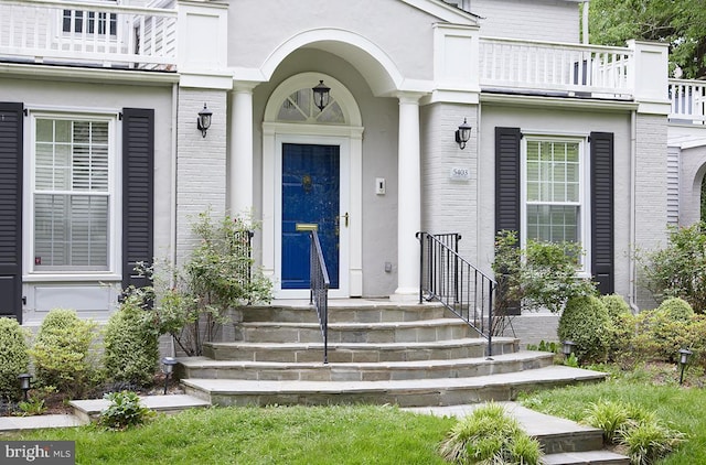 5403 Center St, Chevy Chase, MD 20815 - property entrance with a balcony, stucco siding, and brick siding