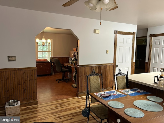 76 Red Burke Ct, Front Royal, VA 22630 - dining space with wainscoting, light wood-type flooring, wooden walls, arched walkways, and a chandelier