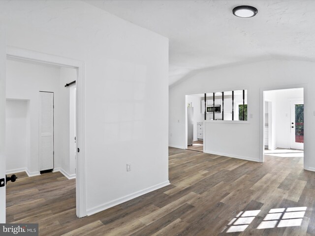 153 Bear Track Rd, Augusta, WV 26704 - unfurnished living room featuring lofted ceiling, wood finished floors, and baseboards