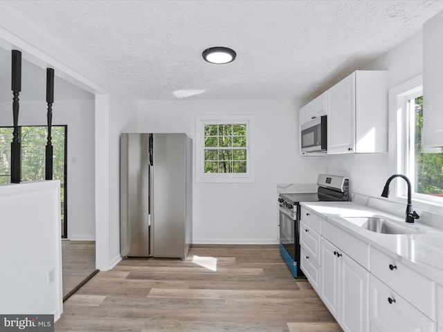 153 Bear Track Rd, Augusta, WV 26704 - kitchen featuring appliances with stainless steel finishes, a sink, healthy amount of natural light, a textured ceiling, and light countertops