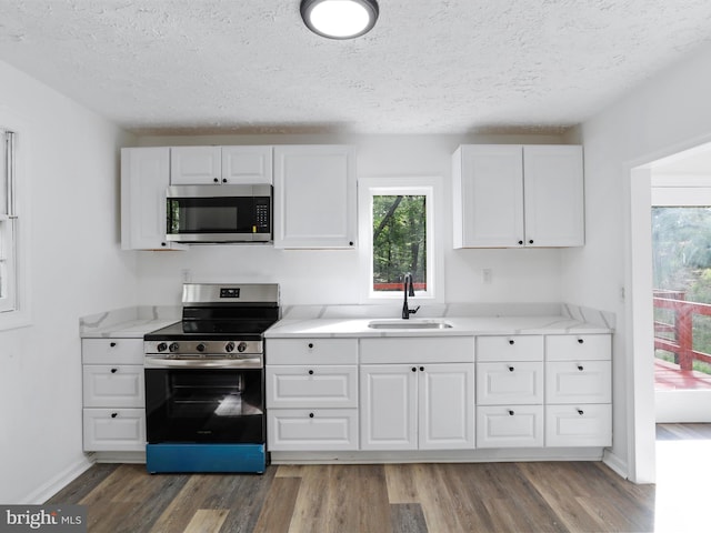153 Bear Track Rd, Augusta, WV 26704 - kitchen with stainless steel appliances, a sink, a textured ceiling, white cabinets, and wood finished floors