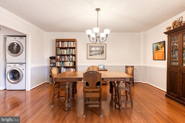 4100 N Charles St Unit 203, Baltimore, MD 21218 - dining area with stacked washer / dryer, a textured ceiling, a chandelier, wood finished floors, and ornamental molding