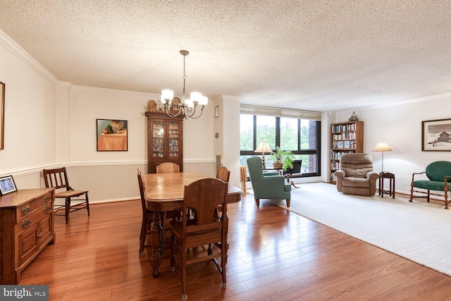 4100 N Charles St Unit 203, Baltimore, MD 21218 - dining room featuring a textured ceiling, crown molding, a chandelier, and wood finished floors
