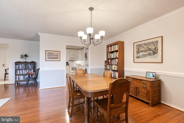 4100 N Charles St Unit 203, Baltimore, MD 21218 - dining area with a textured ceiling, a chandelier, stacked washer and clothes dryer, wood finished floors, and ornamental molding
