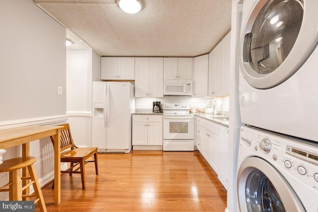 4100 N Charles St Unit 203, Baltimore, MD 21218 - laundry area with stacked washer / dryer, light wood-type flooring, and a textured ceiling