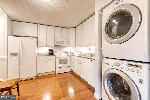 4100 N Charles St Unit 203, Baltimore, MD 21218 - laundry room with stacked washer and clothes dryer, a textured ceiling, and light wood finished floors