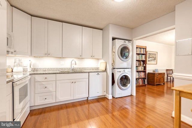 4100 N Charles St Unit 203, Baltimore, MD 21218 - laundry room with stacked washer and clothes dryer, light wood-type flooring, a textured ceiling, and ornamental molding