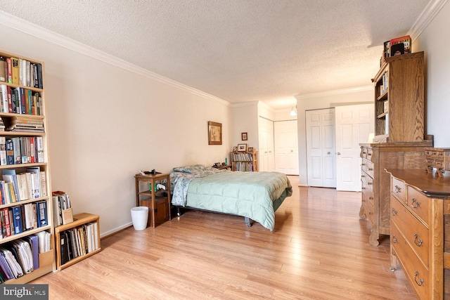 4100 N Charles St Unit 203, Baltimore, MD 21218 - bedroom with light wood-type flooring, a textured ceiling, crown molding, and multiple closets