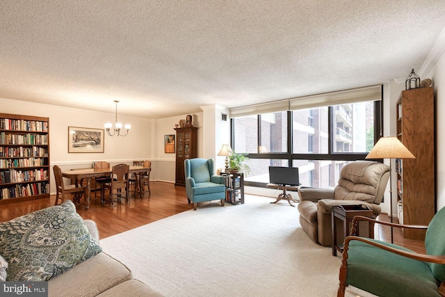 4100 N Charles St Unit 203, Baltimore, MD 21218 - living room with a textured ceiling, ornamental molding, a chandelier, and wood finished floors