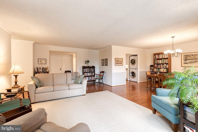 4100 N Charles St Unit 203, Baltimore, MD 21218 - living room with stacked washer / drying machine, dark wood finished floors, a chandelier, a textured ceiling, and crown molding
