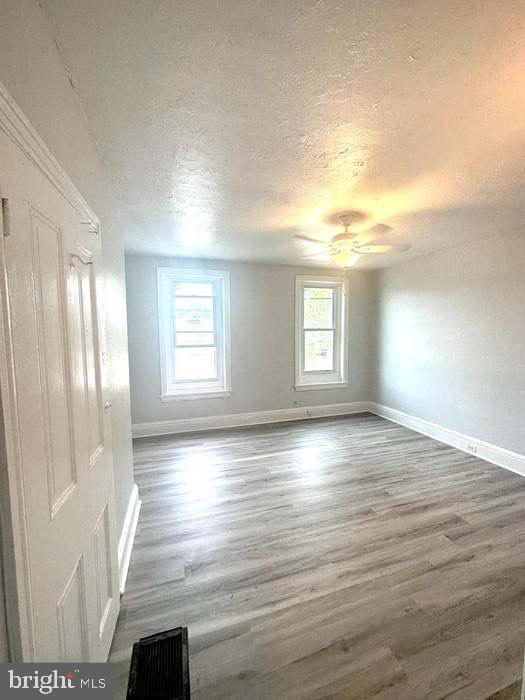 1035 N Pine St, Wilmington, DE 19801 - spare room with a textured ceiling, baseboards, wood finished floors, and ceiling fan