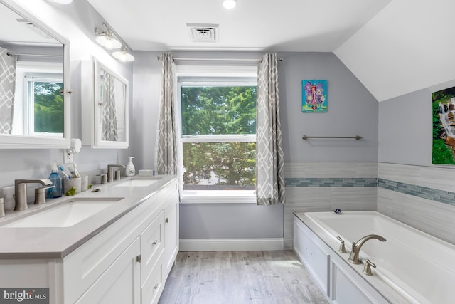 25 N 12th St, Del Haven, NJ 08251 - full bath with double vanity, plenty of natural light, a bath, baseboards, and vaulted ceiling