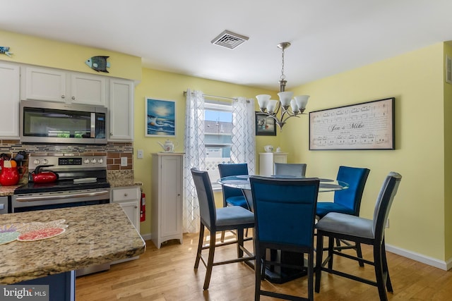 25 N 12th St, Del Haven, NJ 08251 - dining area with a chandelier, light wood-type flooring, and baseboards